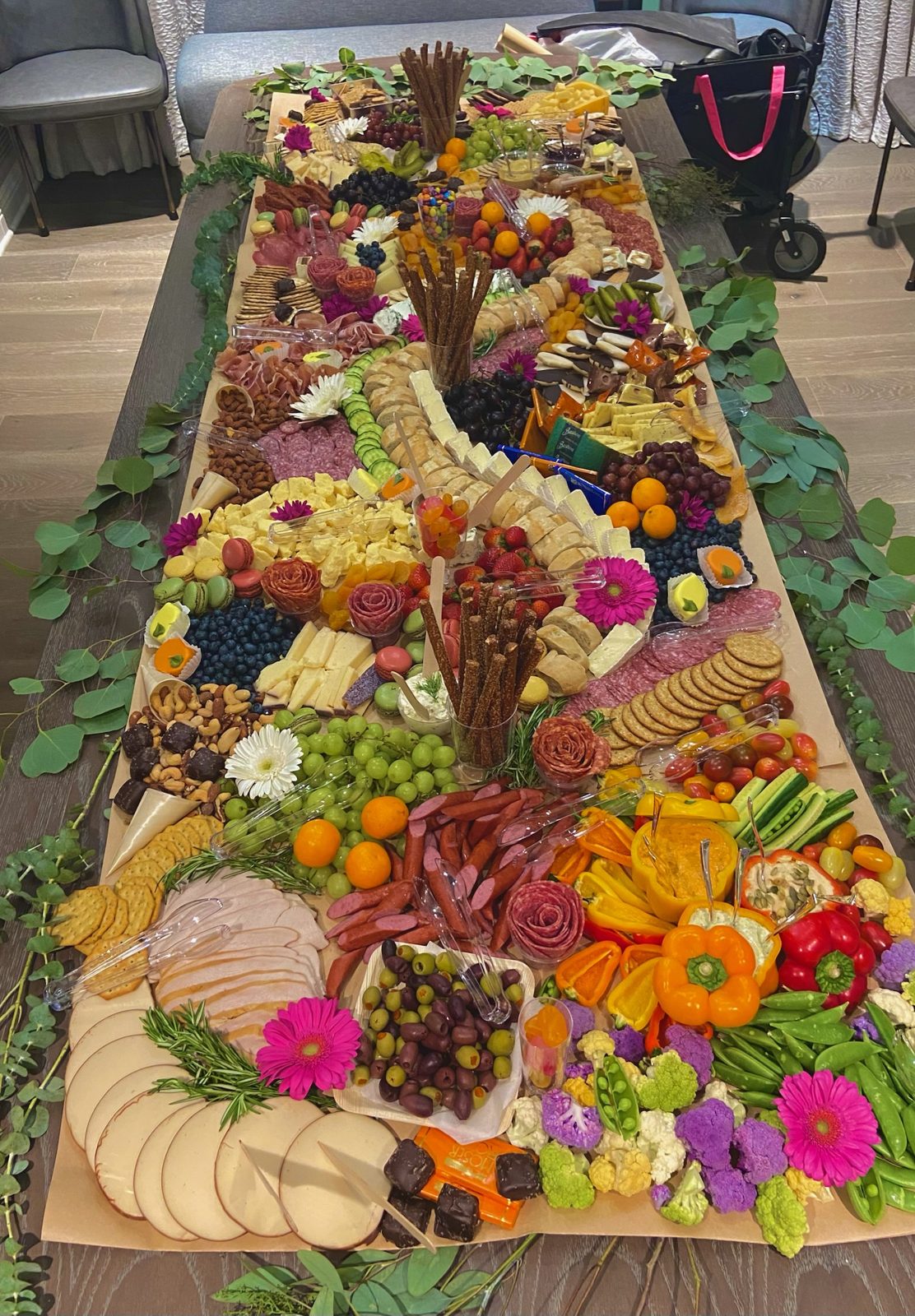 Long grazing table styled with meats, cheeses, fruit, and greenery for an Orlando event