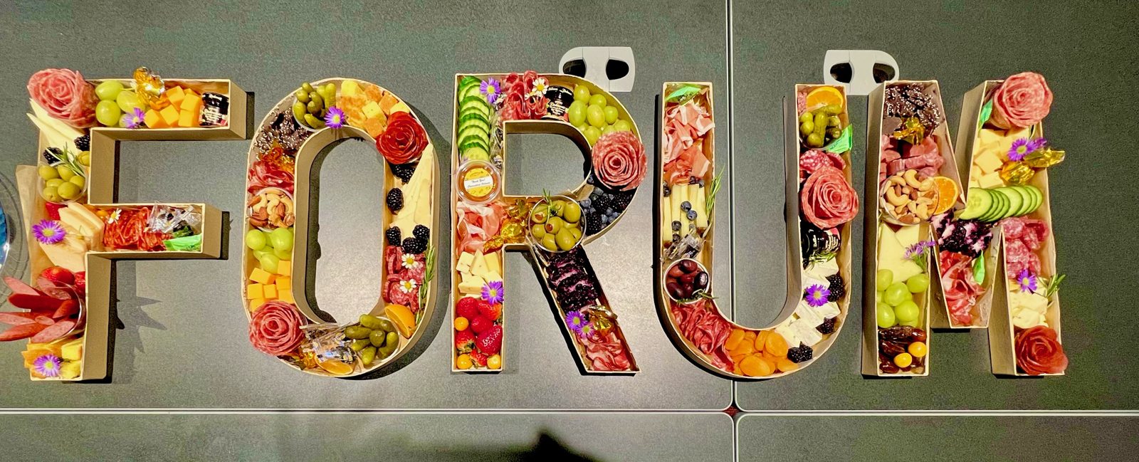Fillable letters spelling FORUM filled with charcuterie