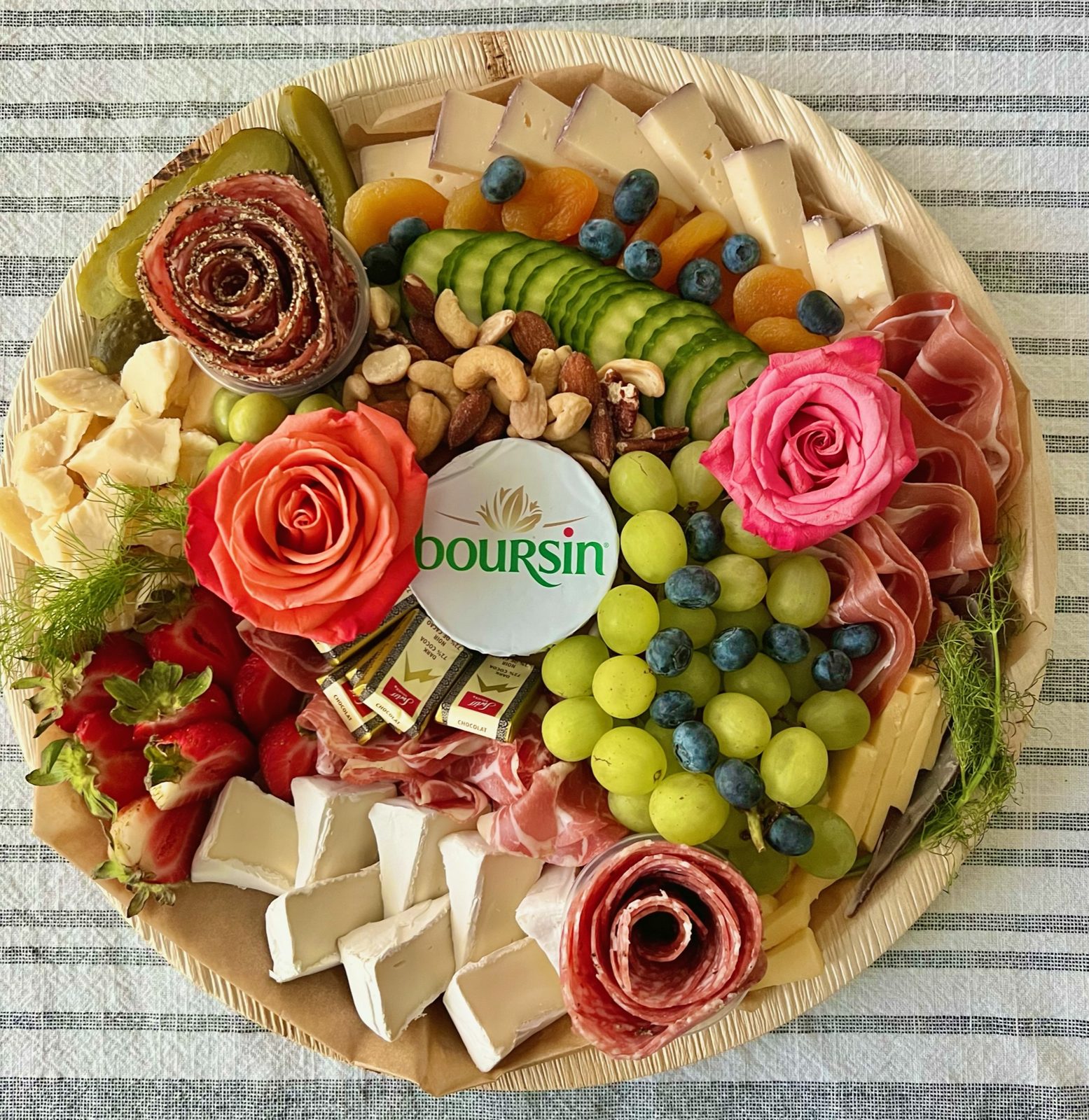 Large round board with salami rose centerpiece and fresh fruit