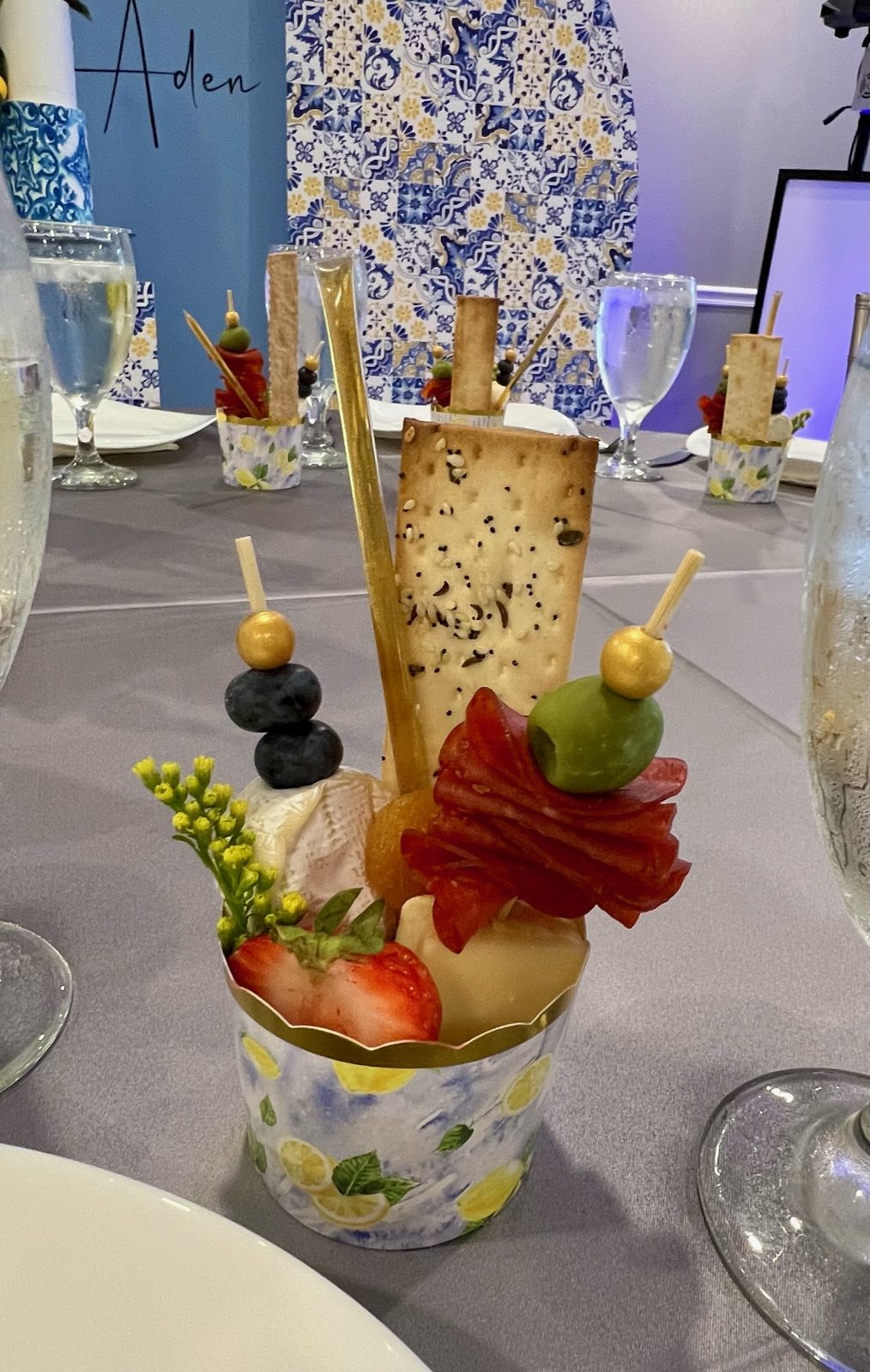 Individual charcuterie cups with meat, cheese, and olive skewers