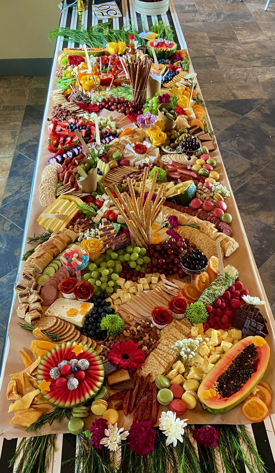 Narrow grazing table styled with tropical fruit and florals